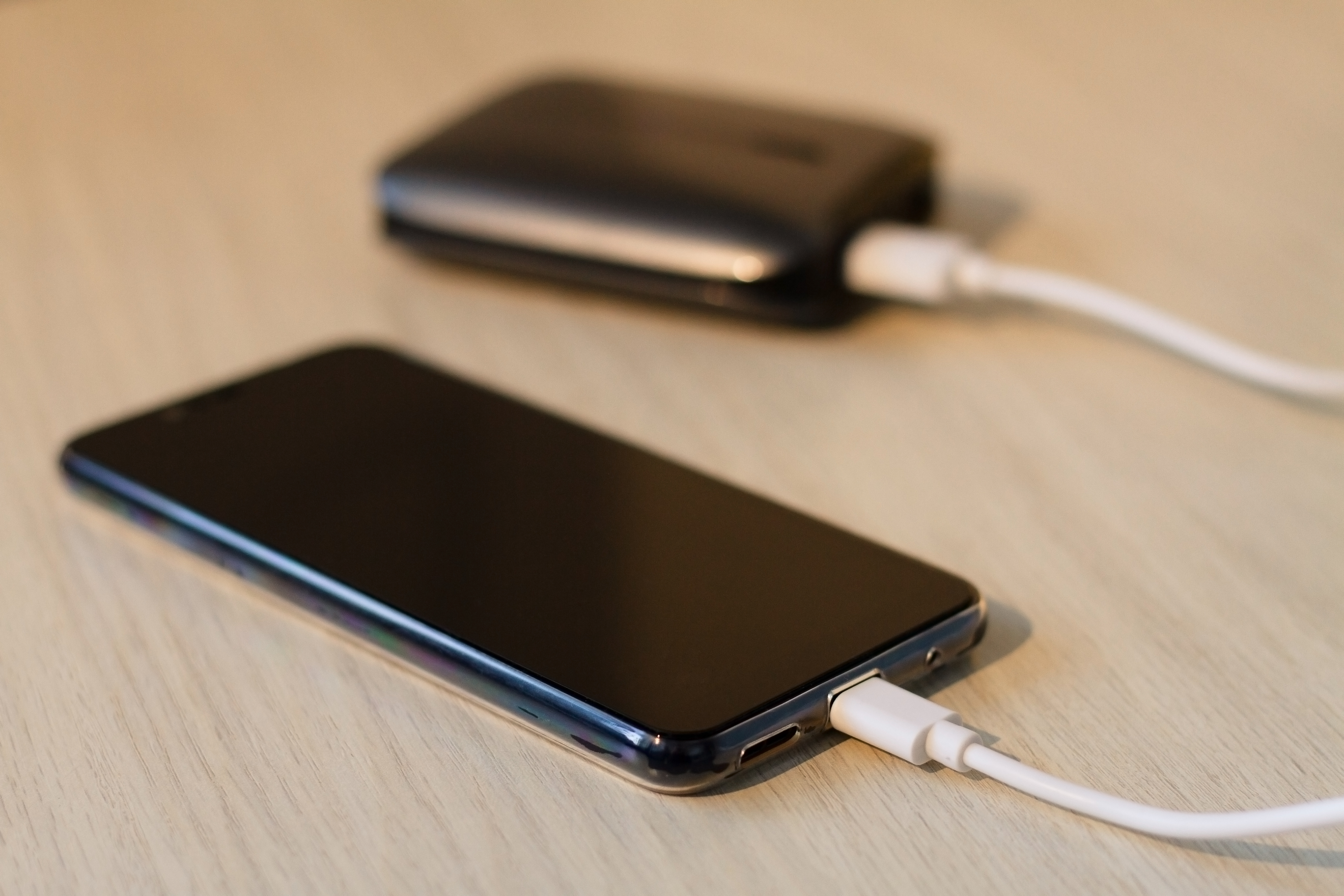 Charging your smartphone from a portable charger, close-up.